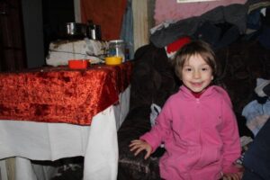 A little girl sitting on the couch in her room
