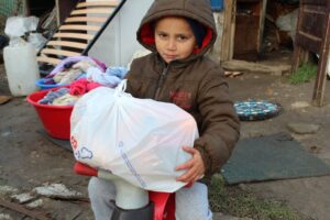 A child holding an umbrella in his hands.