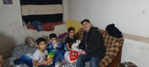 A man sitting on top of a couch next to kids.
