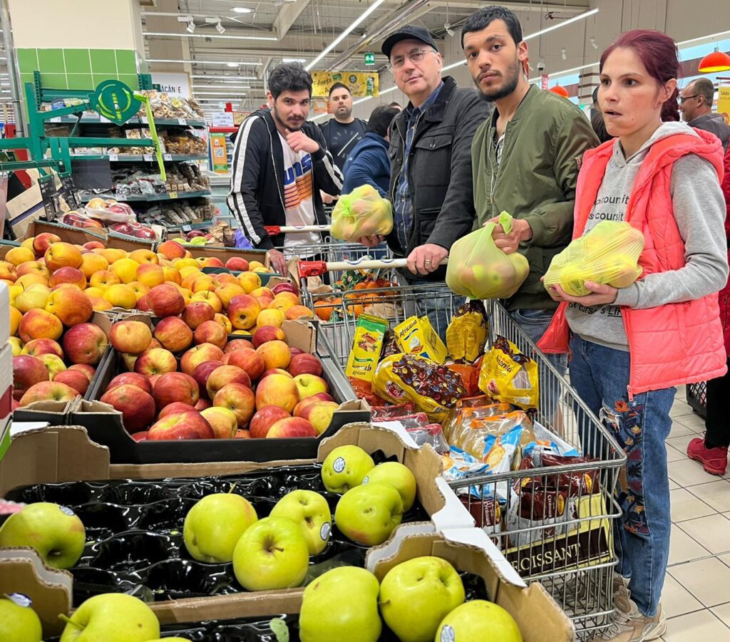 A group of people standing around an apple display.
