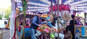 A man and boy on a merry go round.
