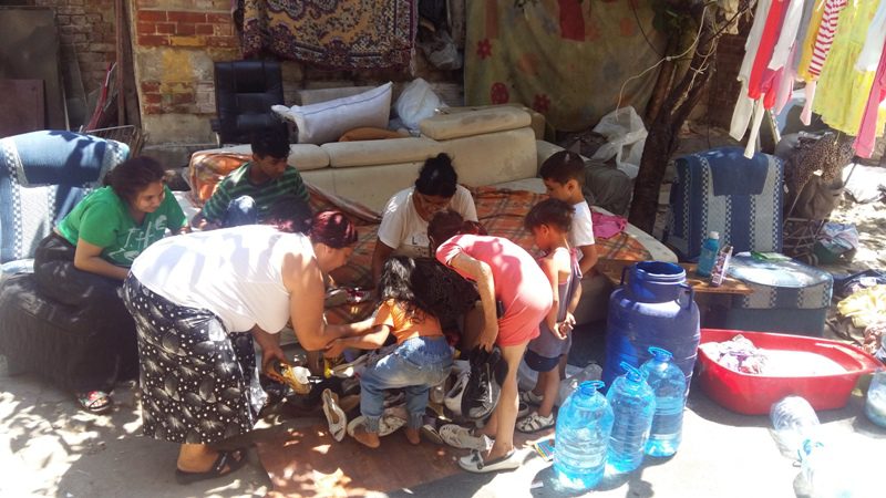 A group of people gathered around some water bottles.