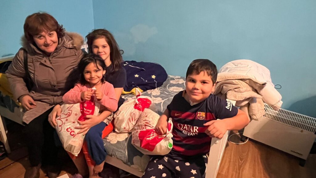 A group of kids sitting on top of a bed.
