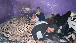 Two people are laying on a bed in a room.