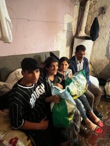 Family sitting together holding grocery bags.