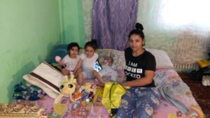 Family sitting on a bed with toys.
