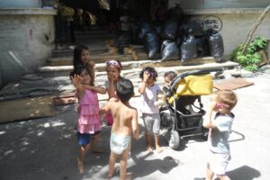 Children playing outside with a stroller.