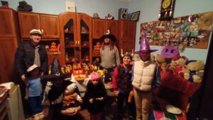 Group in Halloween costumes with decorations indoors.