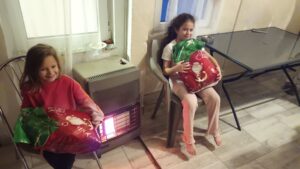 Children holding festive gift bags indoors.